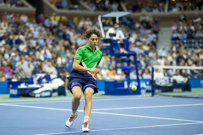 a ball boy at the U.S. Open chases down a tennis ball